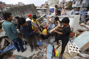 People carry the body of a victim from a damaged house after an earthquake hit, in Kathmandu